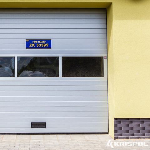 Industrie-Sektionaltor von Krispol mit Lichtband und gelber Fassade